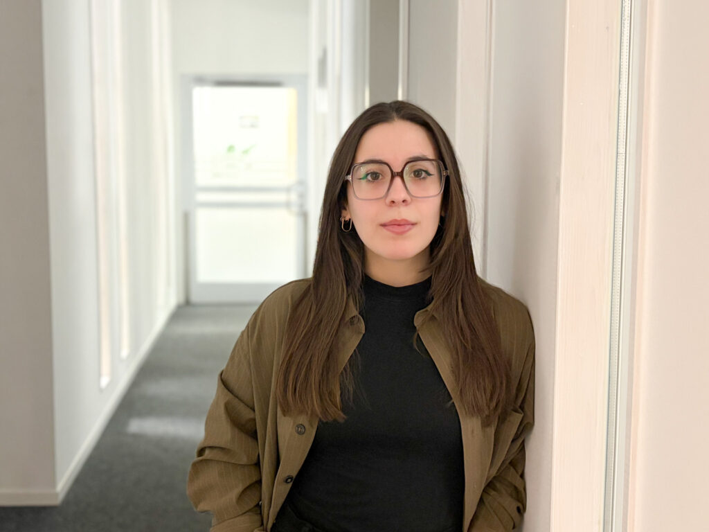 Italienische Frau mit dunklen Haaren, dunkler Kleidung und einer olivgrünen Bluse